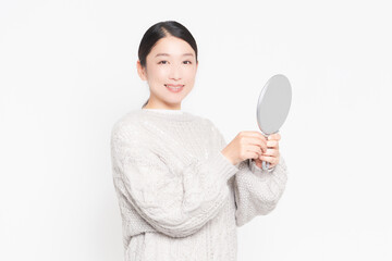 鏡を見て肌のチェックをする女性