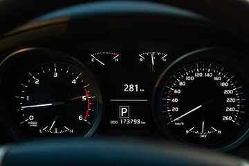 Fototapeta premium Modern car illuminated dashboard closeup. White arrows on Speedometer