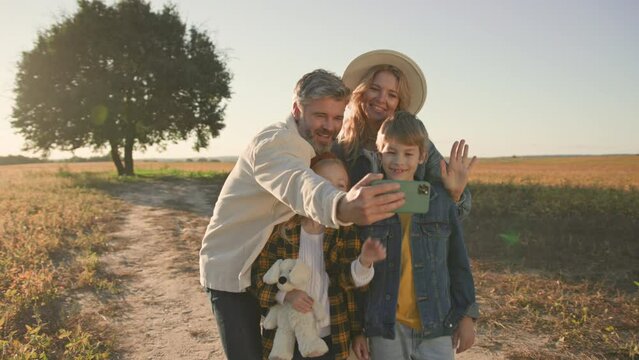 Family taking selfie photo in field. Children, mother, kid, spending time, childhood, summer, mom, smiling, nature, cute, father, countryside. Portrait. Slow motion