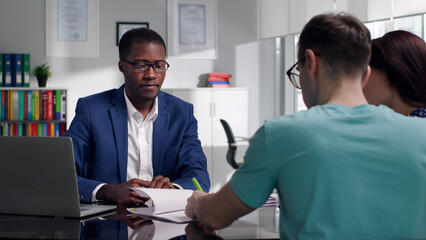 Civil servant advising young couple in modern office