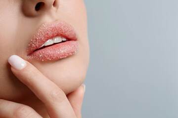 Obraz premium Closeup view of woman with lips covered in sugar on light grey background. Space for text