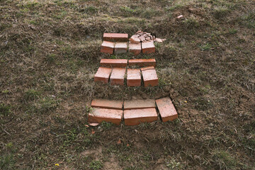 Steps made of red deformed bricks are laid out on a hill.