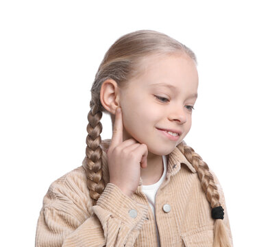 Cute little girl pointing at her ear on white background
