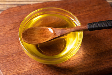 cooking oil in glass bowl with spoon on table