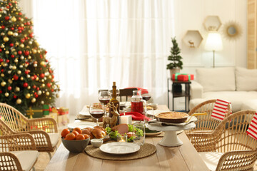 Festive dinner with delicious food and wine on table indoors. Christmas celebration