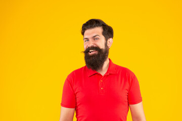 smiling guy with beard and hairstyle on yellow background, portrait