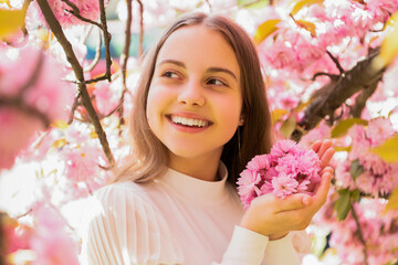 Fototapeta premium glad kid at sakura flower bloom in spring