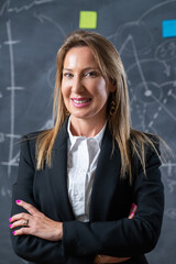 Portrait of successful businesswoman in office. Happy Caucasian woman with beautiful smile in suit resting after hard work posing and looking at camera. Business activity and female leadership concept