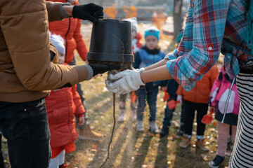 afforestation or volunteer teach children to planting tree sapling in city park