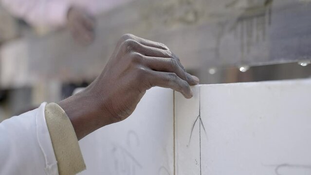 Close up gimbal shot of Marmorists hands measuring block of Makrana marble