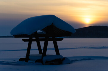 Gazebo for a picnic against the backdrop of sunset. Winter evening.