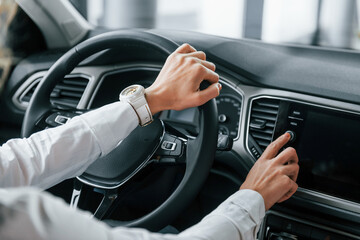 Driving a car. Woman is in autosalon at daytime