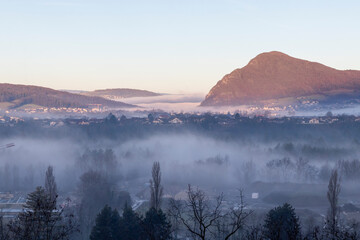 Fototapeta premium Sunrise above the deep misty valley, early morning with fog above the forest, the scenery and the landscape in Annecy, France