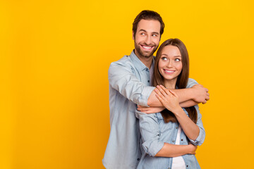 Portrait of attractive cheerful dreamy couple hugging looking idea copy space isolated over bright yellow color background