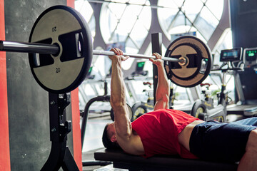 A man lifting weights on a bench press.