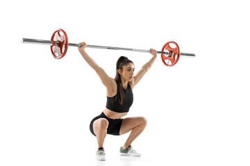 Full length portrait of muscled woman in sportswear exercising with a weight, barbell isolated on...
