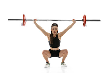 Studio shot of young woman in sportswear exercising with a weight, barbell isolated on white...