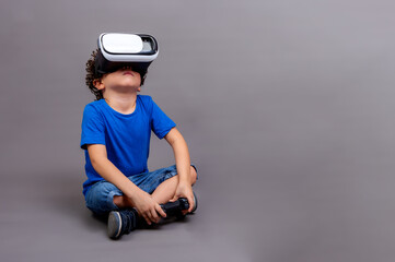 child sitting playing with virtual reality goggles and controller