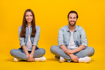 Portrait of attractive cheerful couple sitting resting sale discount isolated over bright yellow color background