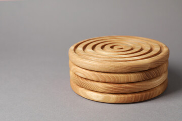 Stylish wooden cup coasters on light grey background, space for text
