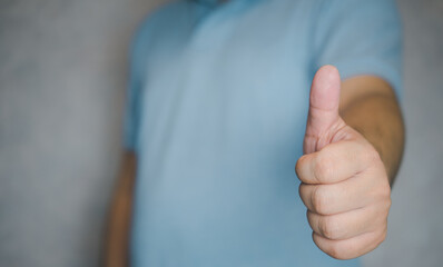 Closeup of male hand showing thumbs up