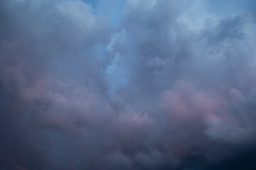 Naklejka na ściany i meble Natural background of dramatic dark stormy colorful clouds