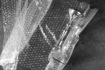 Elegant silver candlesticks with bubble wrap on dark grey table, flat lay