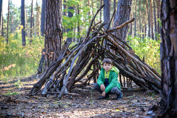 In the spring or autumn in the pine forest the boy plays he buil