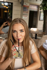 Beautiful young woman drinking cocktail