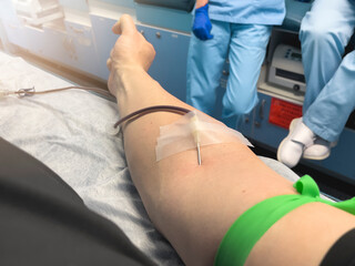 Point of view of male arm during blood donation against nurses