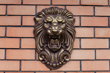 lion head monument on brick wall