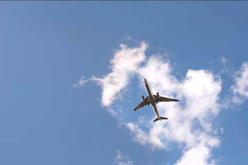 Airplane  in blue sky with light clouds