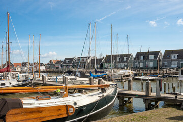 Fototapeta na wymiar Yachts moored in the harbor in the Dutch countryside in early spring against the blue sky.