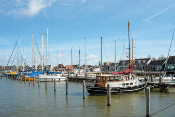 Fototapeta na wymiar Yachts moored in the harbor in the Dutch countryside in early spring against the blue sky.