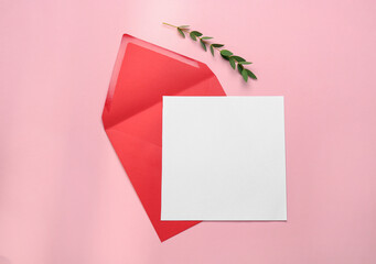 Red envelope with blank letter and plant on pink background, flat lay