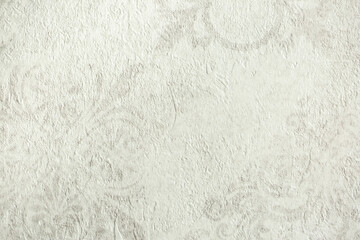 Light background of decorative plaster with abstract spots. Unusual texture of white or gray wall with beautiful patterns, creative surface background. Finishing coating for building cladding.