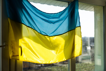 Support Ukraine. Ukrainian flag on the window. Place for text.