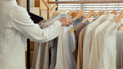 Professional small business owner partner in clothing design,The shop owner is checking the products according to the customer's order, in order to deliver it to the customer.