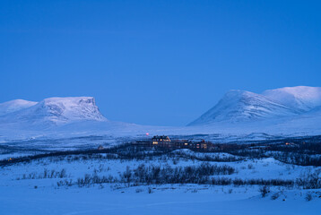 Fototapeta na wymiar Dusk at the small town of Abisko and the famous Lapporten in winter.