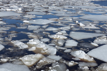 ice drift on the river in early spring, pieces of ice float on the water