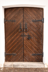old vintage wooden front door with forged hinges, handles and latch after restoration