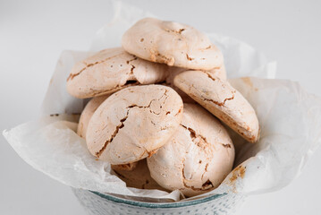 Lots of delicious meringues in a plate. Meringue folded in a slide in a blue plate. Meringue on a white background