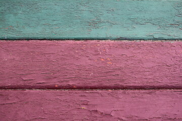 Obraz premium Old pink worn wall with horizontal stripes and a green board on the upper background.
