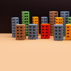 Colored paper houses top view. Abstract city architecture landscape, simplified town layout with high-rise buildings, skyscrapers with many windows. beige background, copy space.