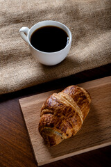 Croissant with a cup of full coffee,directly above	
