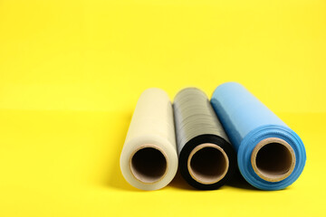 Rolls of different stretch wrap on yellow background. Space for text