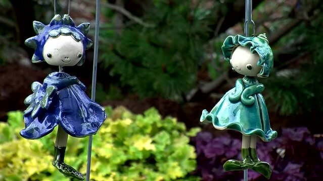 Zwei herzige Elfenfiguren als Gartendekoration bewegen sich anm&uuml;tig im Wind