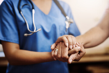 You dont have to face your challenges alone. Cropped shot of an unrecognizable female nurse holding a senior womans hands in comfort. - Powered by Adobe