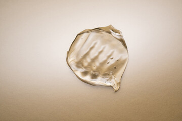Transparent hyaluronic gel on a beige background.