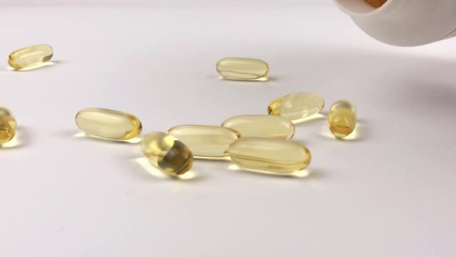 Omega 3 yellow pills with fish oil on a white surface. Natural medicine concept